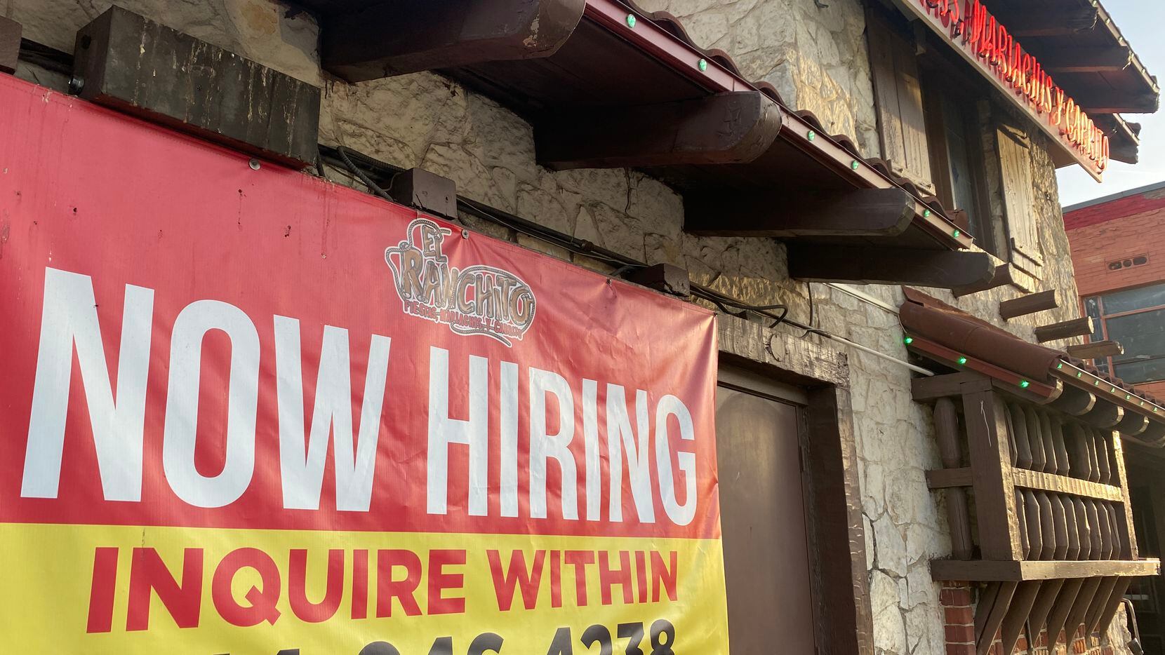 A "NOW HIRING' sign advertises the help needed at El Ranchito Mexican restaurant on...