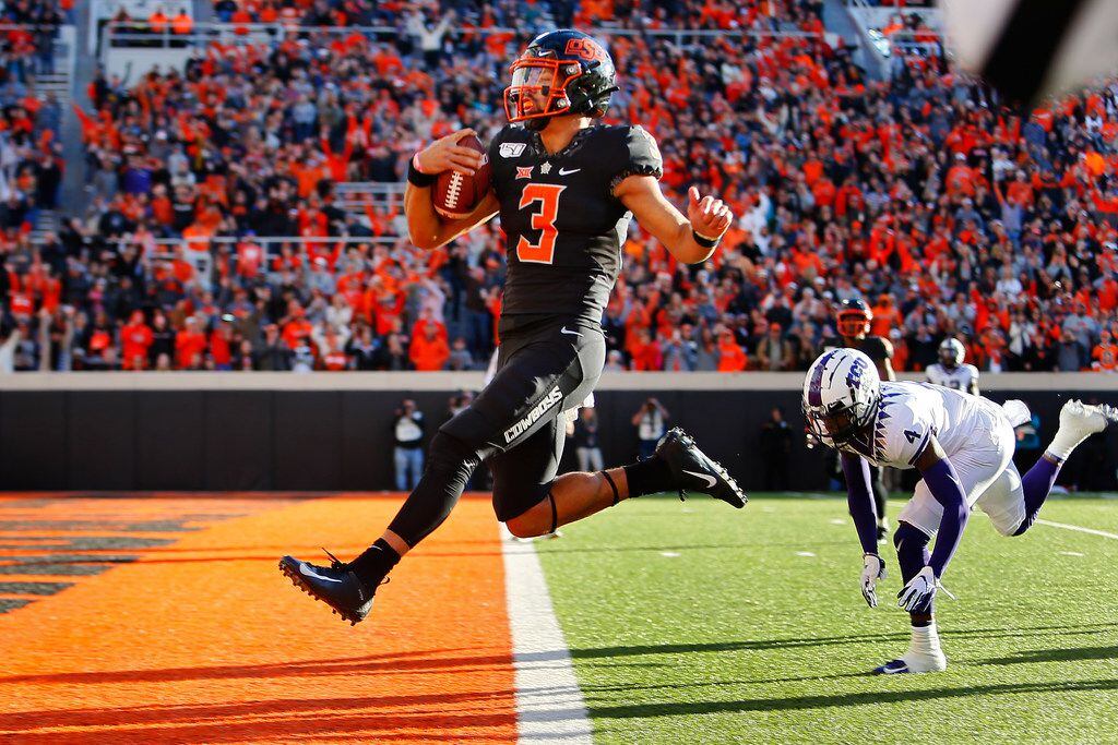 STILLWATER, OK - NOVEMBER 2:  Quarterback Spencer Sanders #3 of the Oklahoma State Cowboys leaps into the end zone for a 43-yard touchdown against safety Keenan Reed #4 of the TCU Horned Frogs only to have it called back for an illegal shift in the fourth quarter on November 2, 2019 at Boone Pickens Stadium in Stillwater, Oklahoma.  OSU won 34-27.