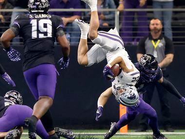 Kansas State Wildcats running back Deuce Vaughn (22) is flipped over after having his legs...
