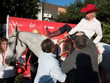 Richard Branson dismounts from a horse after arriving at the ground breaking for his hotel...