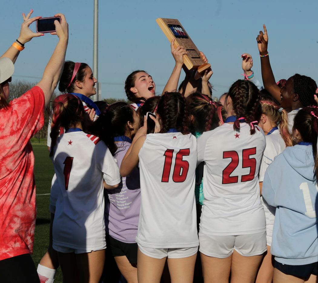 The Ursuline girls soccer team celebrates with their trophy after winning heir game against...