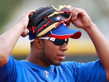 Infielder Elvis Andrus dons his glove during the Texas Rangers practice on Saturday February...