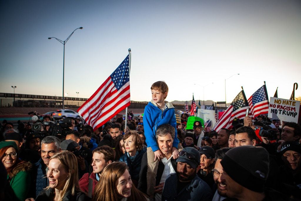 Beto O'Rourke carries his son Henry on his shoulders in El Paso as they march along the...