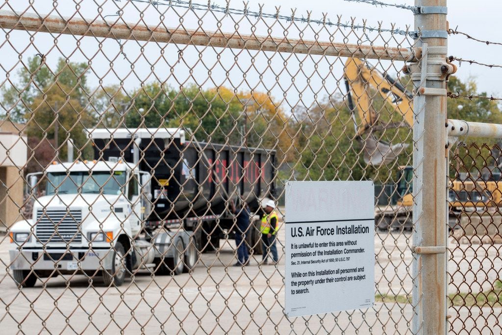 Workers prepare a truck to remove debris from the former Texas Air National Guard armory as...