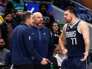 Dallas Mavericks guard Luka Doncic (77) talks with assistant coach Greg St. Jean (left) and...