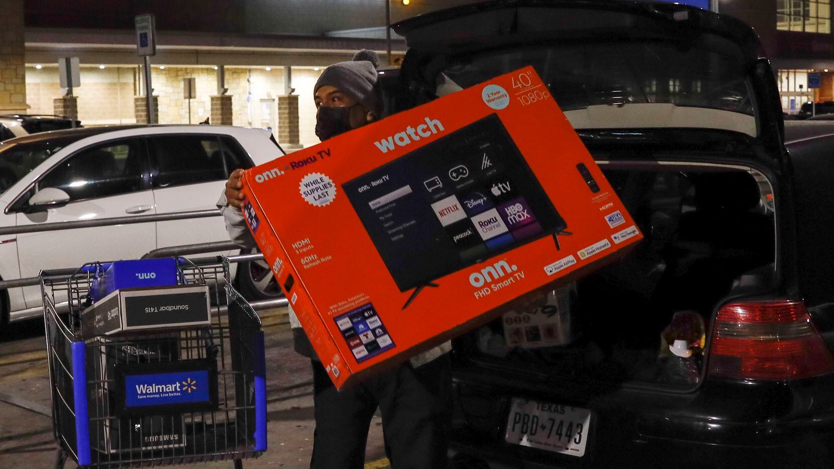 Louis Garcia, loads a 40-inch TV into the back of his car just before 6 a.m. during Black Friday shopping in Dallas on Friday, Nov. 26, 2021. Garcia said it was only the second time he had shopped on Black Friday. He found what he wanted at the right prices.