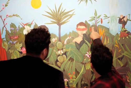 Marco Saucedo, derecha, señala un detalle en la pintura “Boys in the Garden” de Armando...