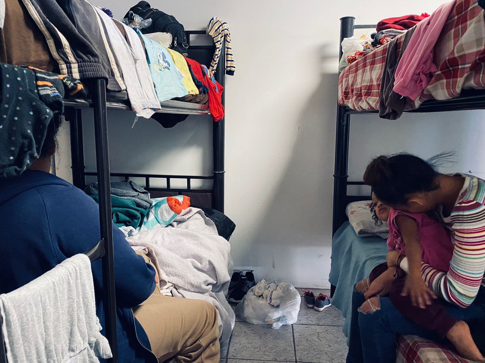 Two Honduran mothers cuddle their toddlers this week inside a migrant shelter in Mexico. Both women were detained by Mexico's National Guard. 