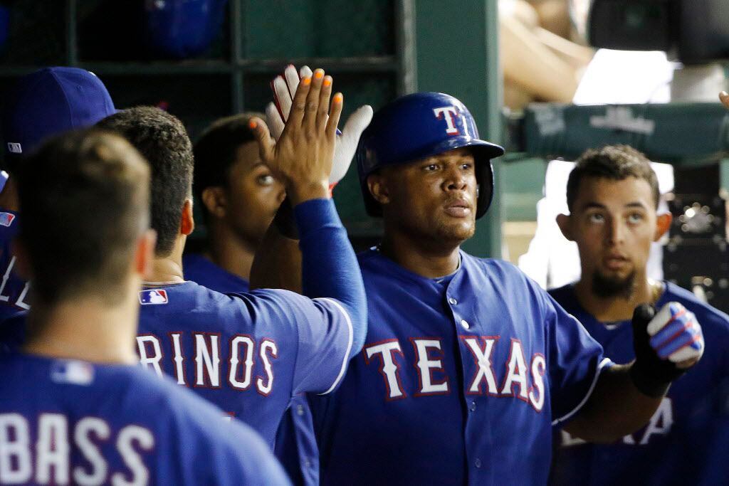 Texas Rangers third baseman Adrian Beltre (29) high fives his teammates after scoring a run...