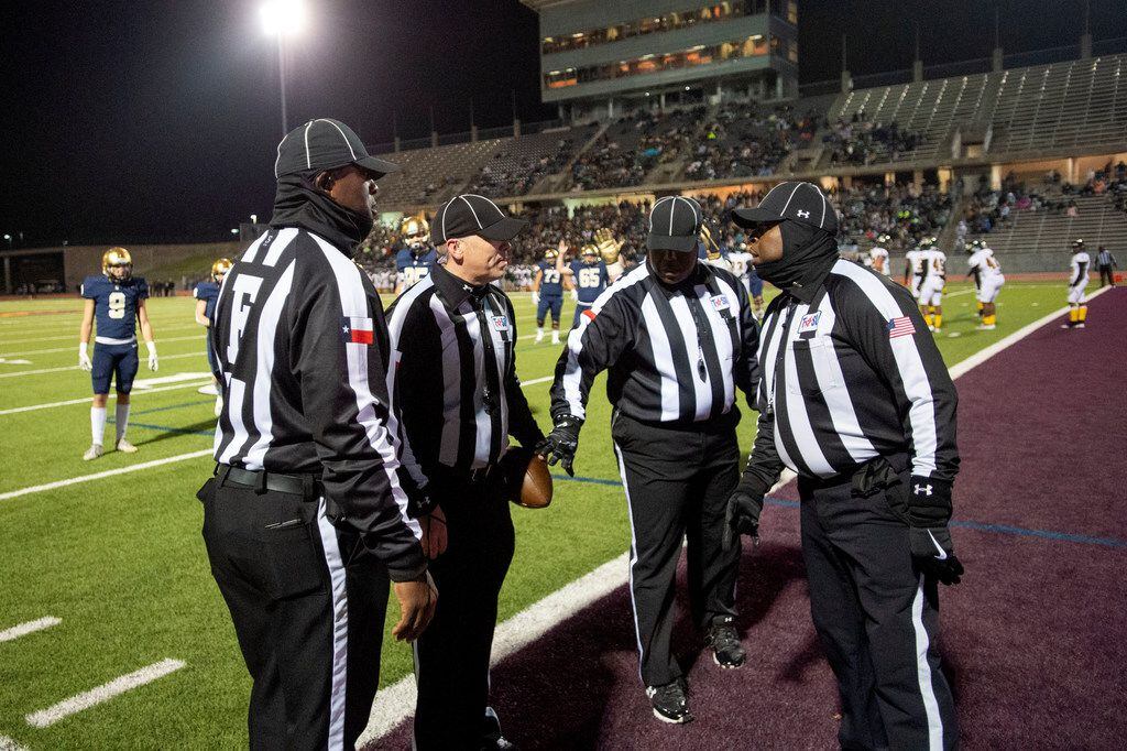 Referees confer after a controversial play in the end zone on which a Jesuit touchdown...