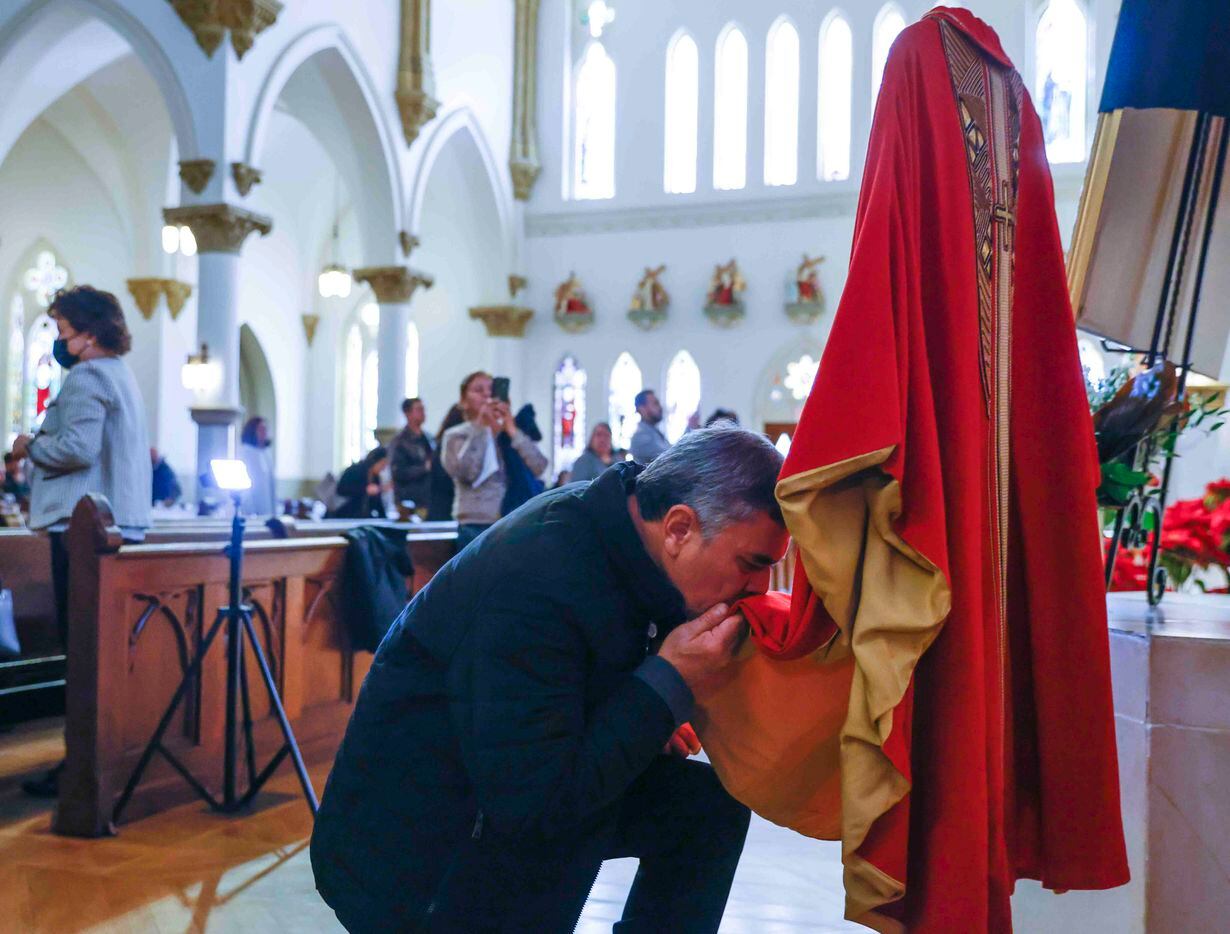 Orlando Saul Garcia kisses the vestment of late Pope Emeritus Benedict XVI following a...