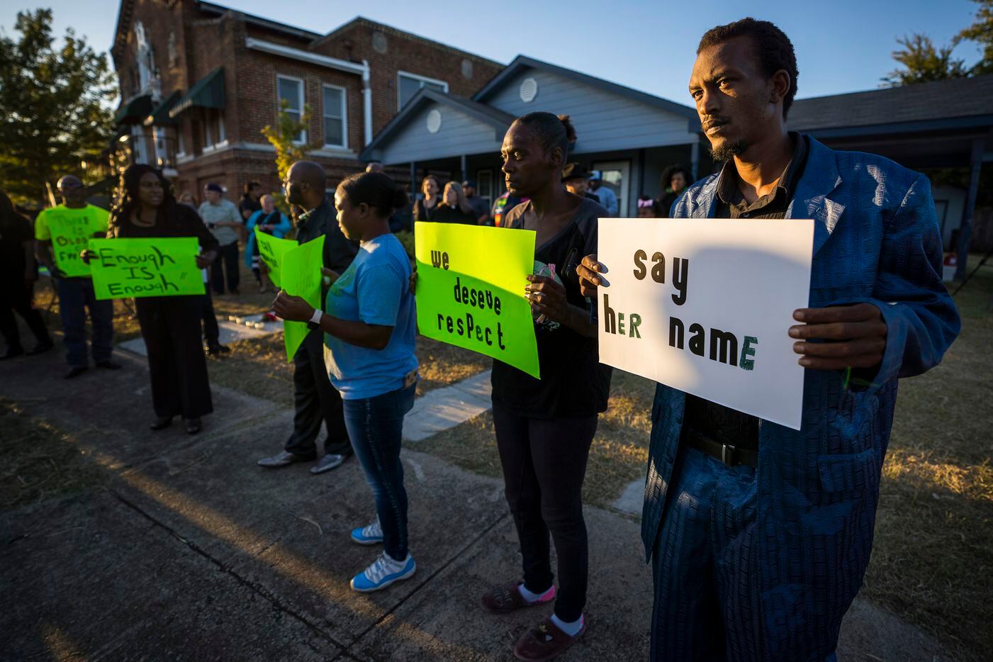 Protestors gather outside the house (right) where Atatiana Jefferson was shot and killed,...