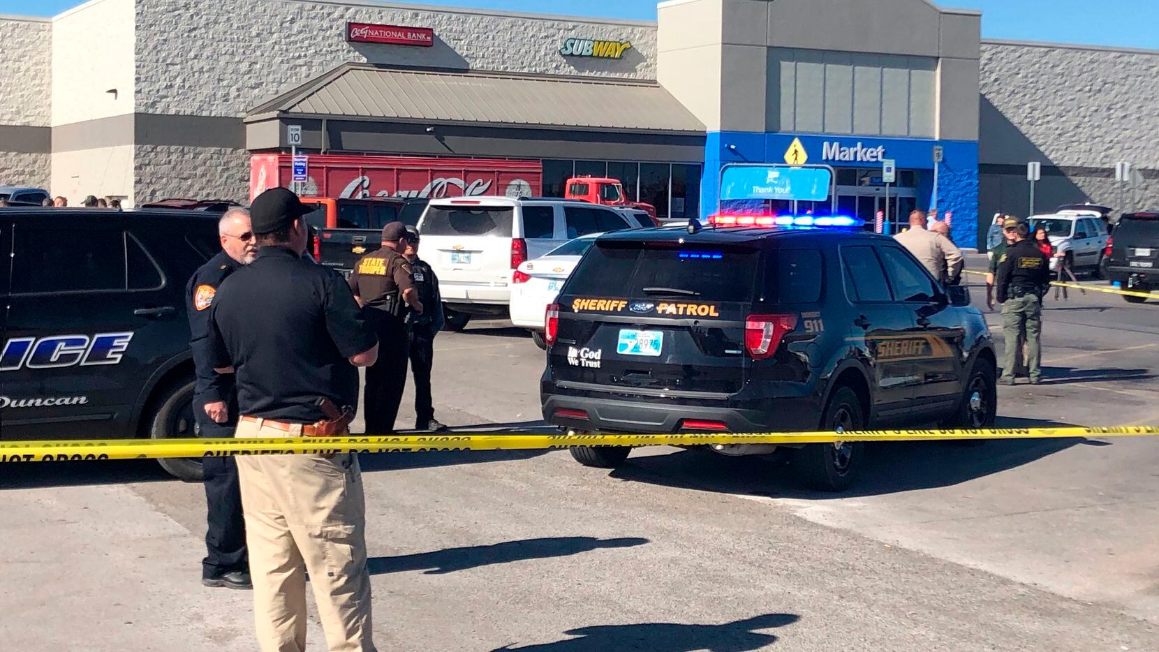 Law enforcement personnel investigate outside a Walmart where two men and a woman were fatally in Duncan, Okla.