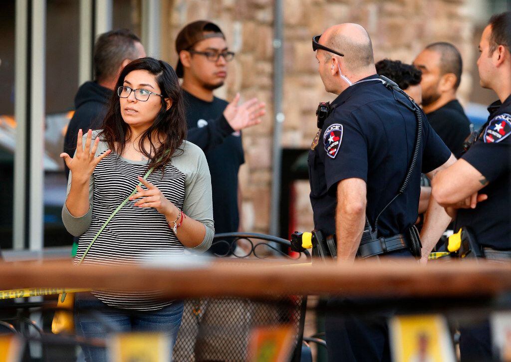 A woman talks with Arlington police investigating a shooting at Zona Caliente Sports Bar on...