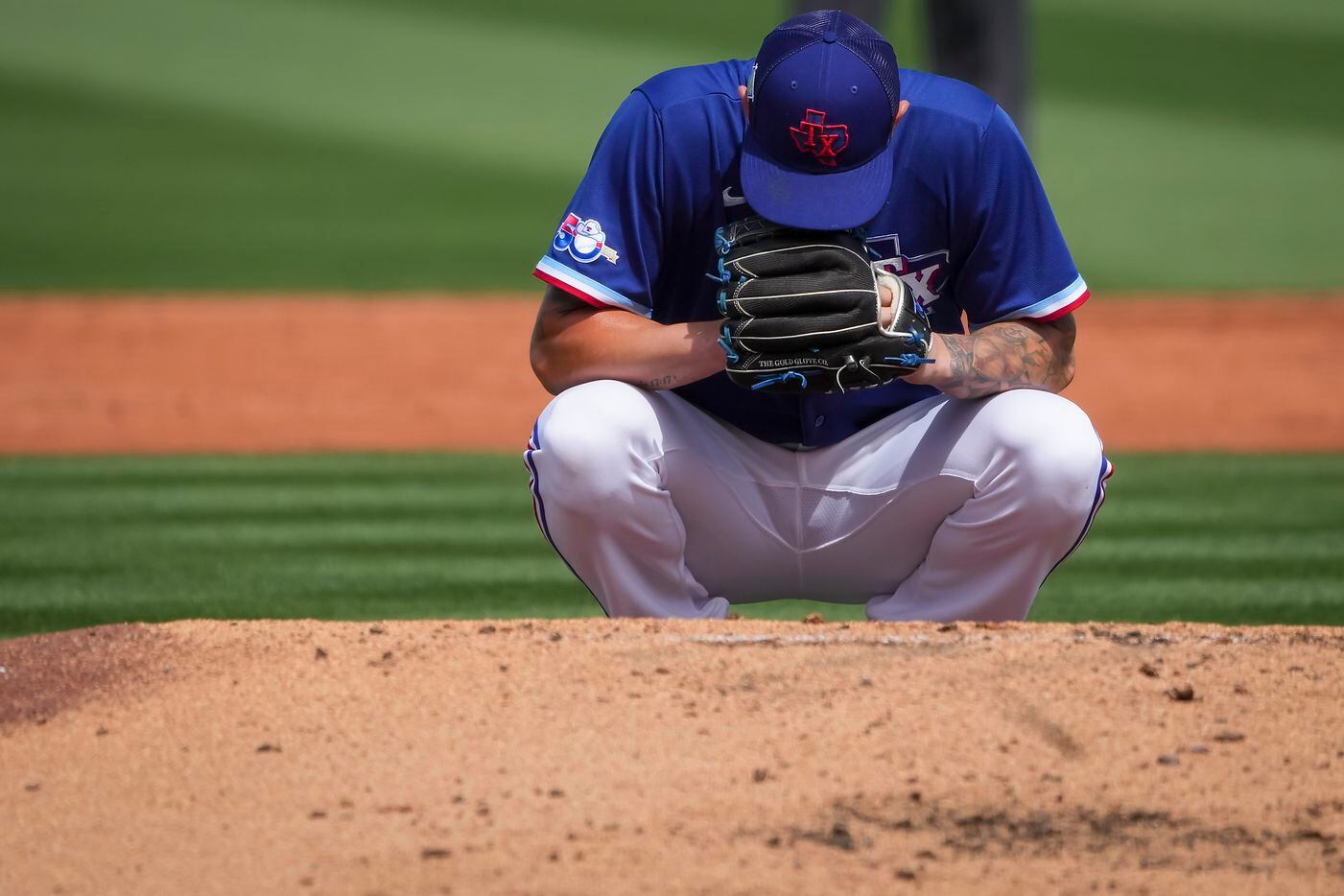 Texas Rangers pitcher Joe Barlow crouches behind the mound before pitching during the third...