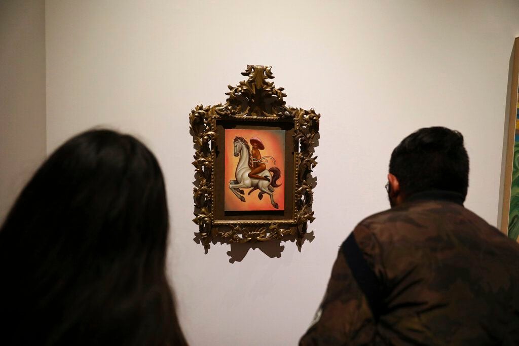 Visitantes observan una pintura que muestra al revolucionario mexicano Emiliano Zapata...
