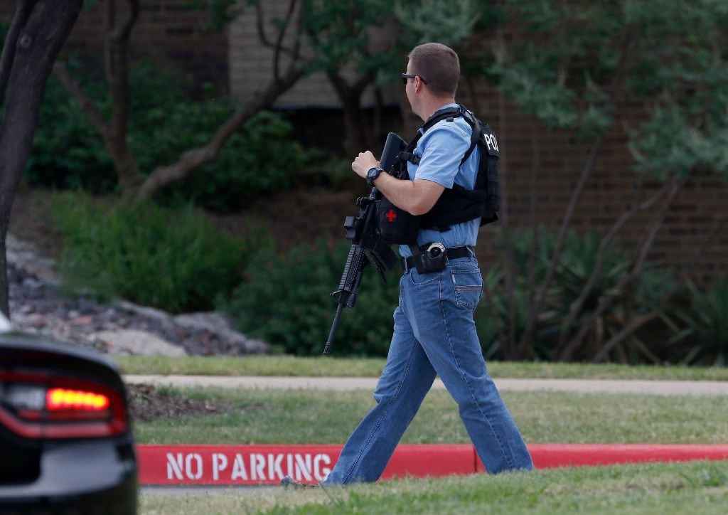 An Irving police officer works at the shooting scene.