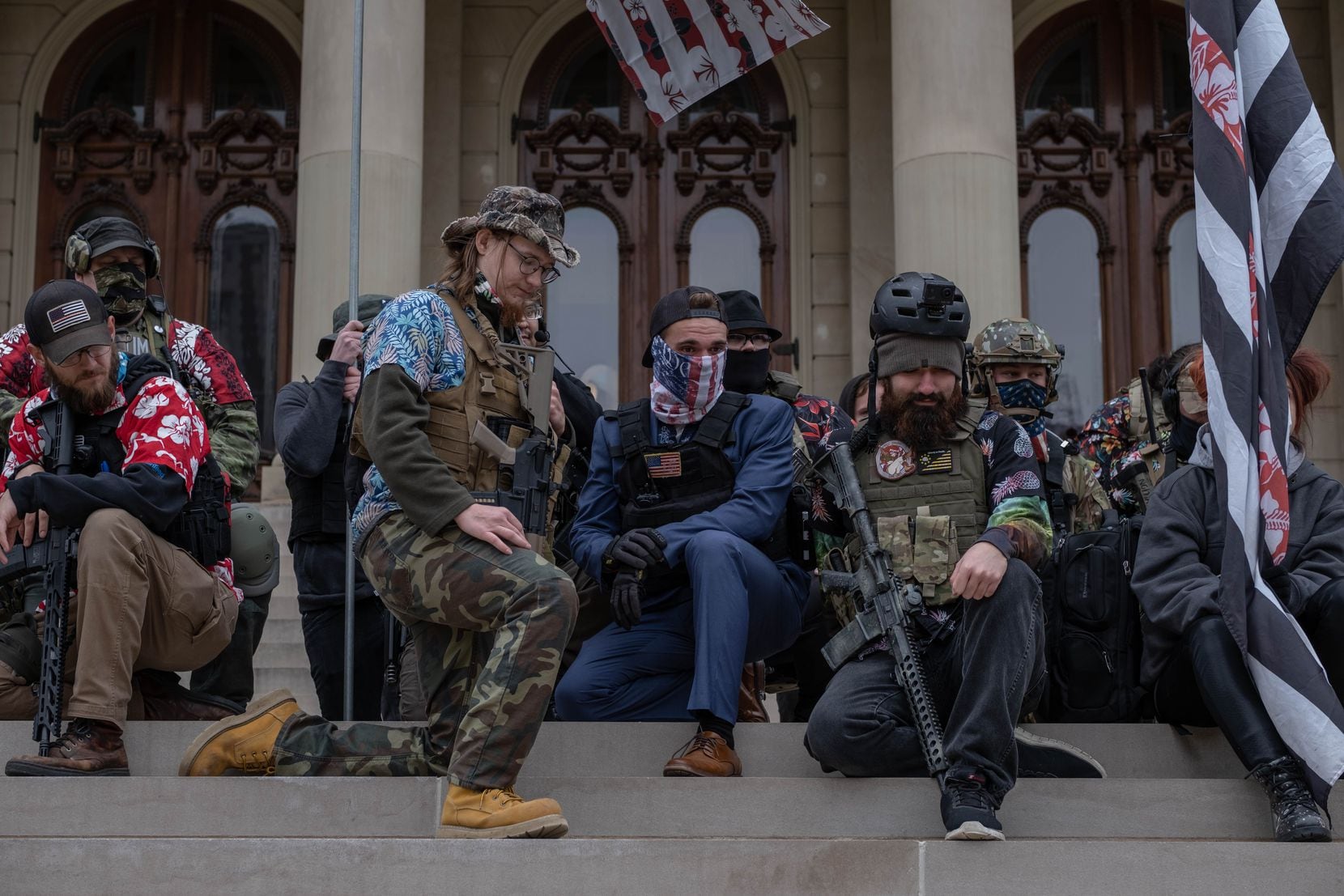 Boogaloo Boys kneel on the steps of the Michigan capitol in Lansing on Oct. 17, 2020. Two...