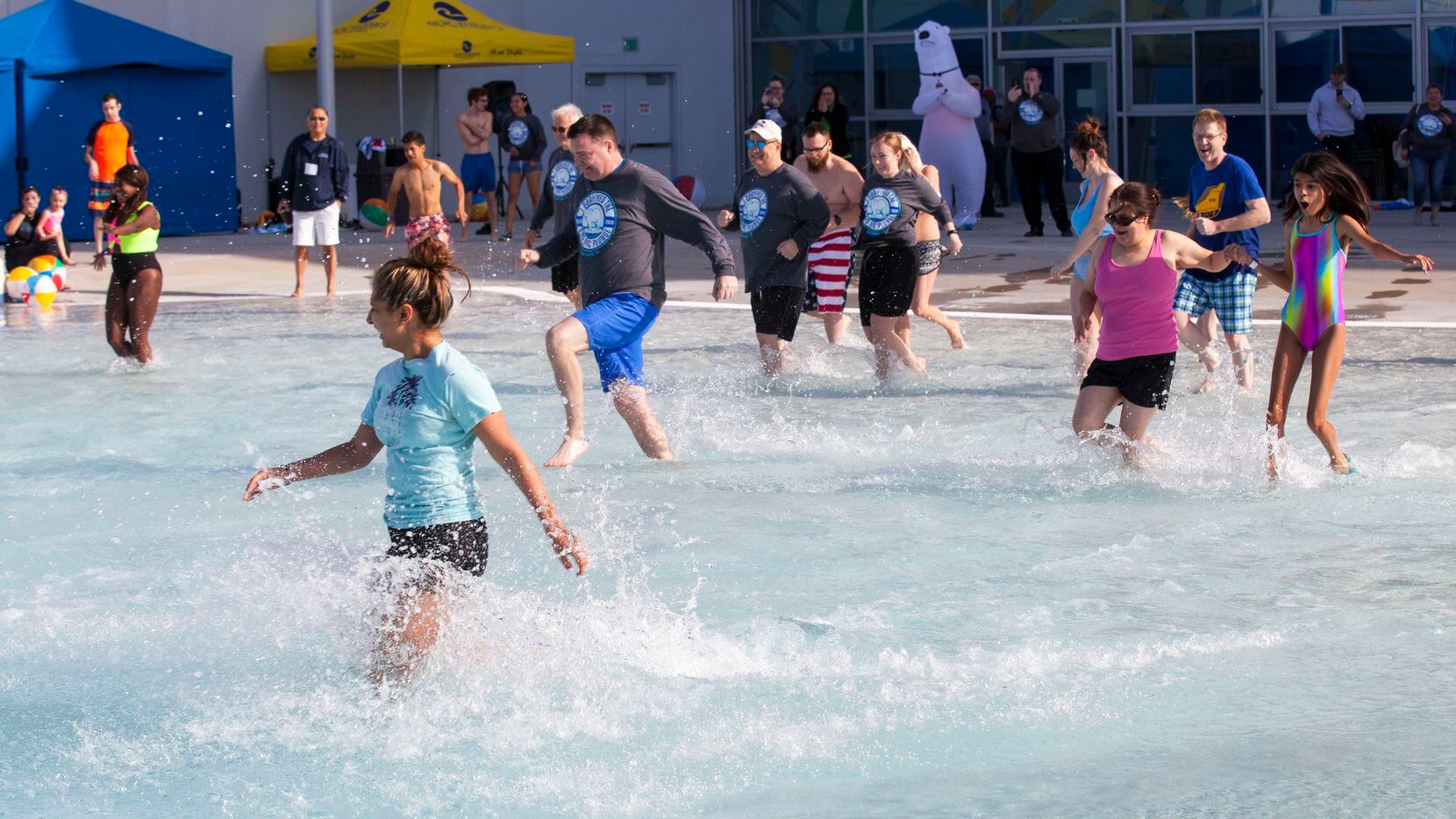 Swimmers wade into an outdoor pool at Epic Waters in Grand Prairie during the annual polar...
