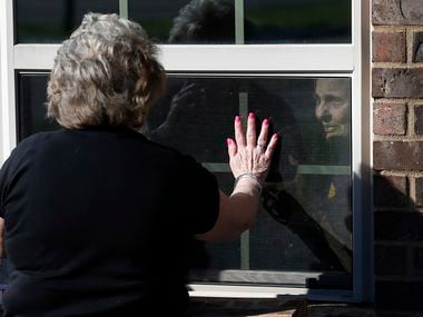 Cindy Goleman waves goodbye to her mother Peggy White from opposites sides of the window at The Pavilion at Creekwood, a healthcare and rehabilitation center in Mansfield, Texas on Tuesday, March 24, 2020. Peggy White had a stroke in late January. Cindy Goleman is one of those people with parents and/or loved ones in nursing homes, hospitals or skilled healthcare facilities who can't visit in person. Goleman visits by looking through the window as she talks to her on the phone.