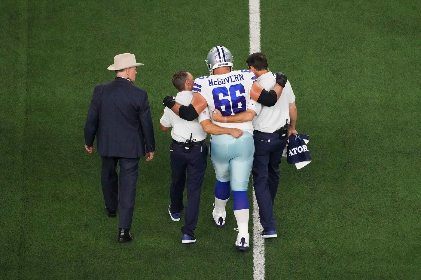 Dallas Cowboys offensive lineman Connor McGovern (66) is helped off the field after being...