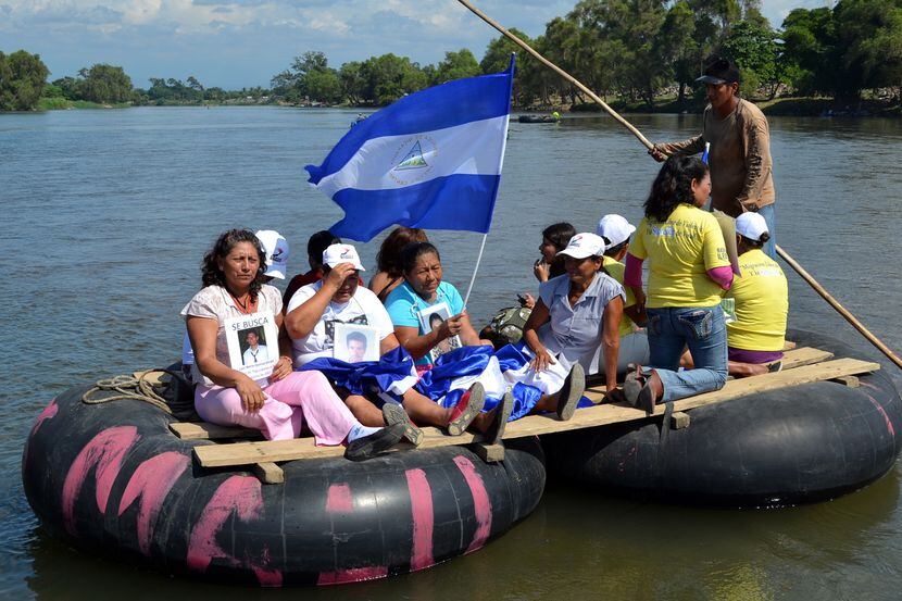 Una balsa con inmigrantes centroamericanos se acerca a la frontera con México, en el estado...