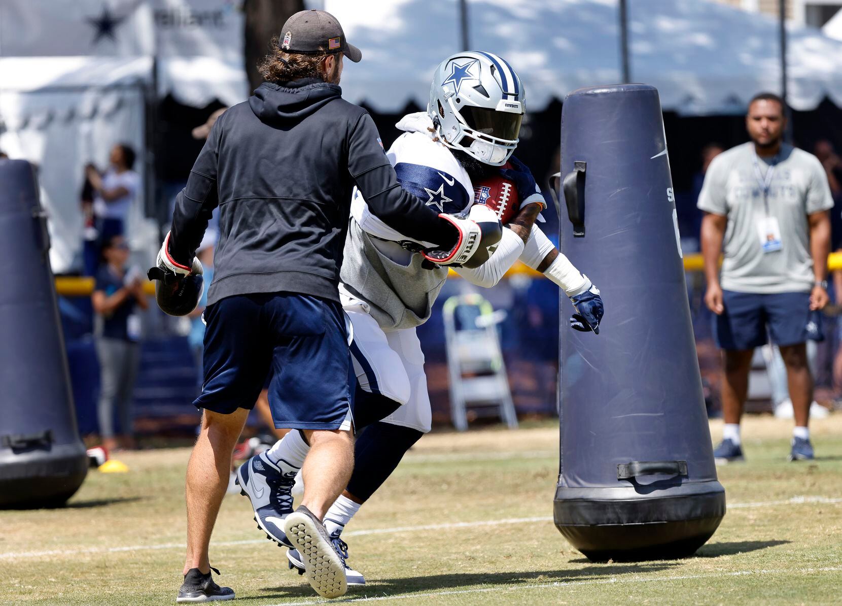 Dallas Cowboys running back Ezekiel Elliott (21) runs through a punching drill as he...