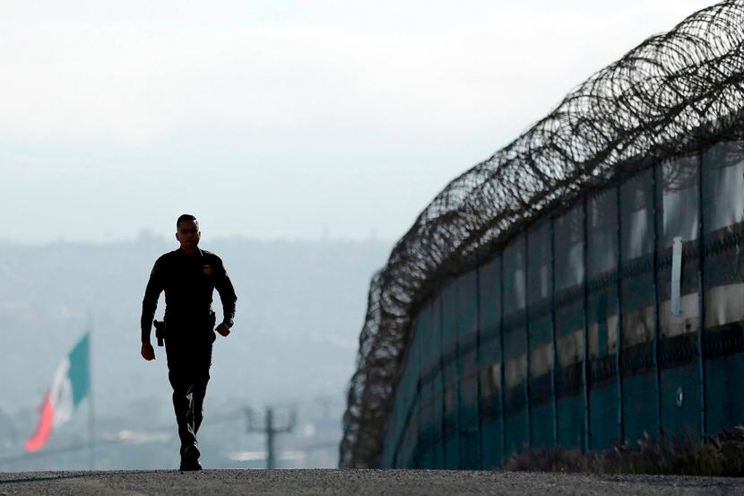 Agente camina por el muro entre San Diego y México./AP
