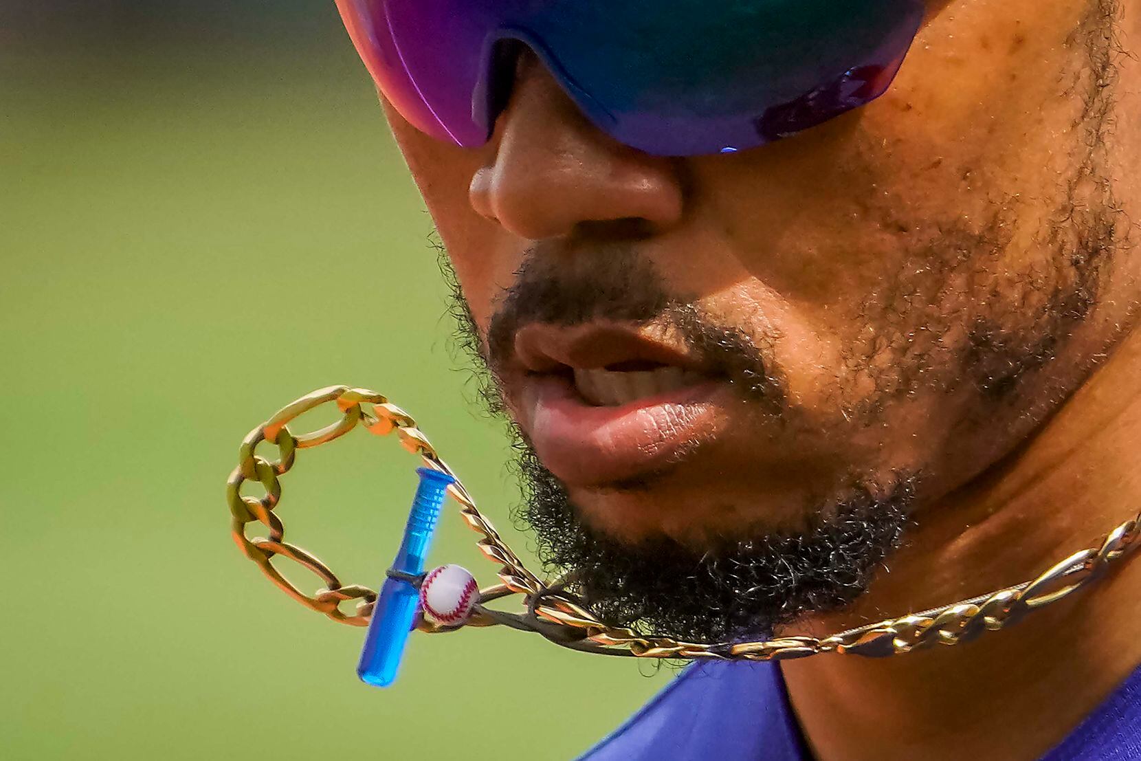 Los Angeles Dodgers right fielder Mookie Betts’ baseball talismans bounced around his neck as he ran off the field during a spring training game against the Texas Rangers in March in Surprise, Ariz. Betts said his father gave him the gold chain in high school, and a young fan presented him with the plastic bat and ball when he played for the Boston Red Sox.