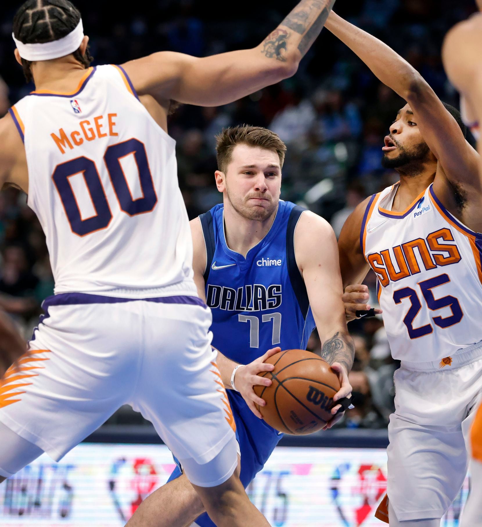 Dallas Mavericks guard Luka Doncic (77) drives between Phoenix Suns center JaVale McGee (00)...