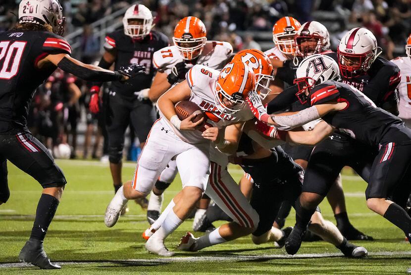 Rockwall quarterback Lake Bennett (5) scores on a 3-yard run during overtime in a District...