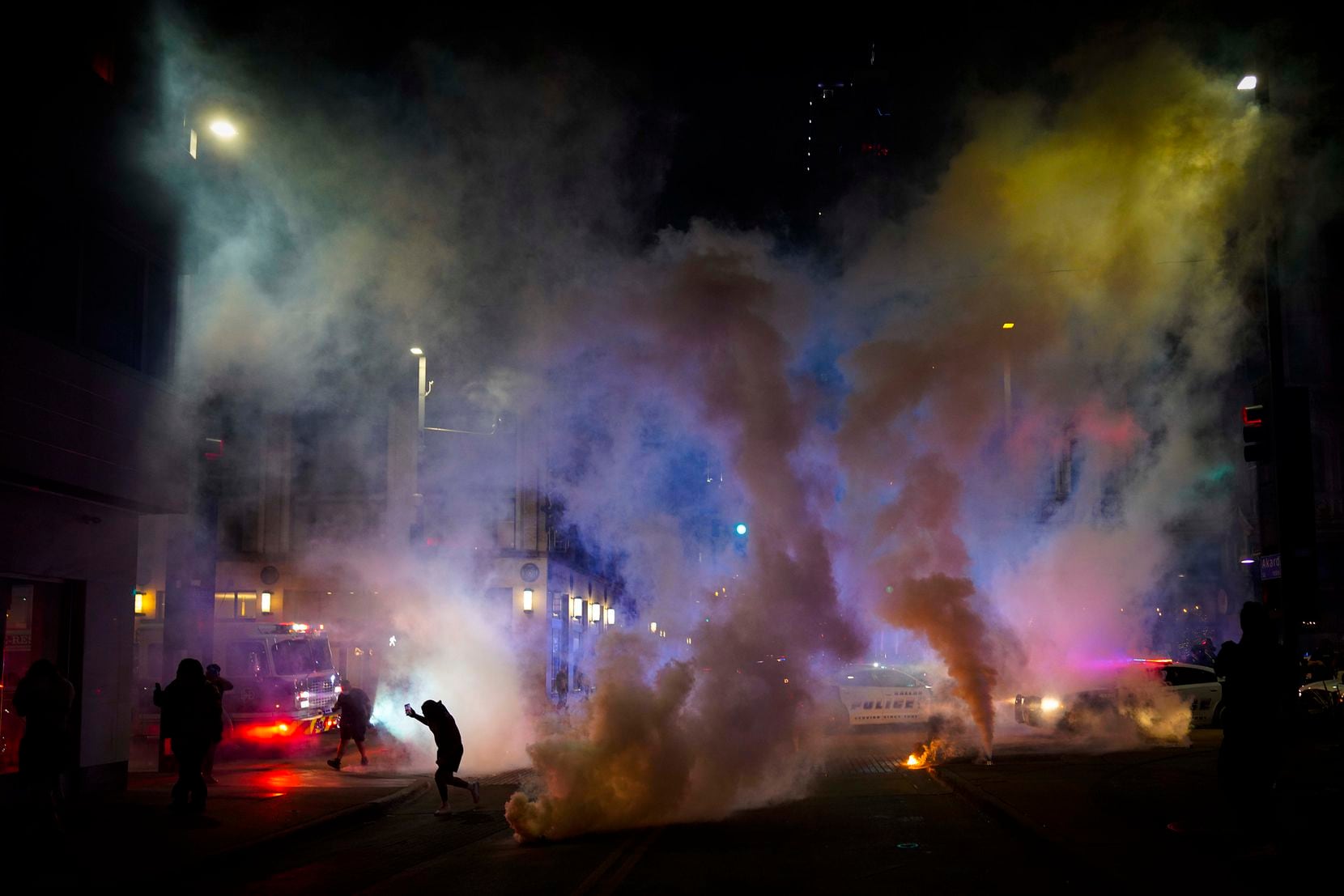 Teargas is deployed by Dallas police to disperse a group of people at the corner of Akard...