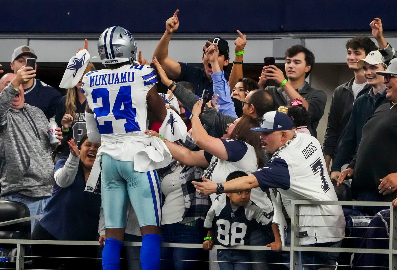 Dallas Cowboys safety Israel Mukuamu celebrates with fans after intercepting a hail-mary in...