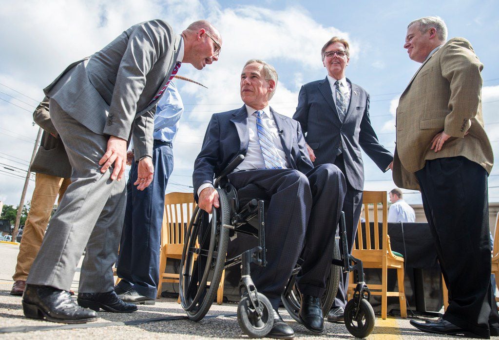 Gov. Greg Abbott listens to Speaker Dennis Bonnen after Abbott signed a bill that limits property tax growth at an Austin restaurant on June 12. The same day, Bonnen and top lieutenant Rep. Dustin Burrows met with conservative activist Michael Quinn Sullivan, who's accused the two House leaders of making an improper quid pro quo offer. Sullivan says he rejected the offer.