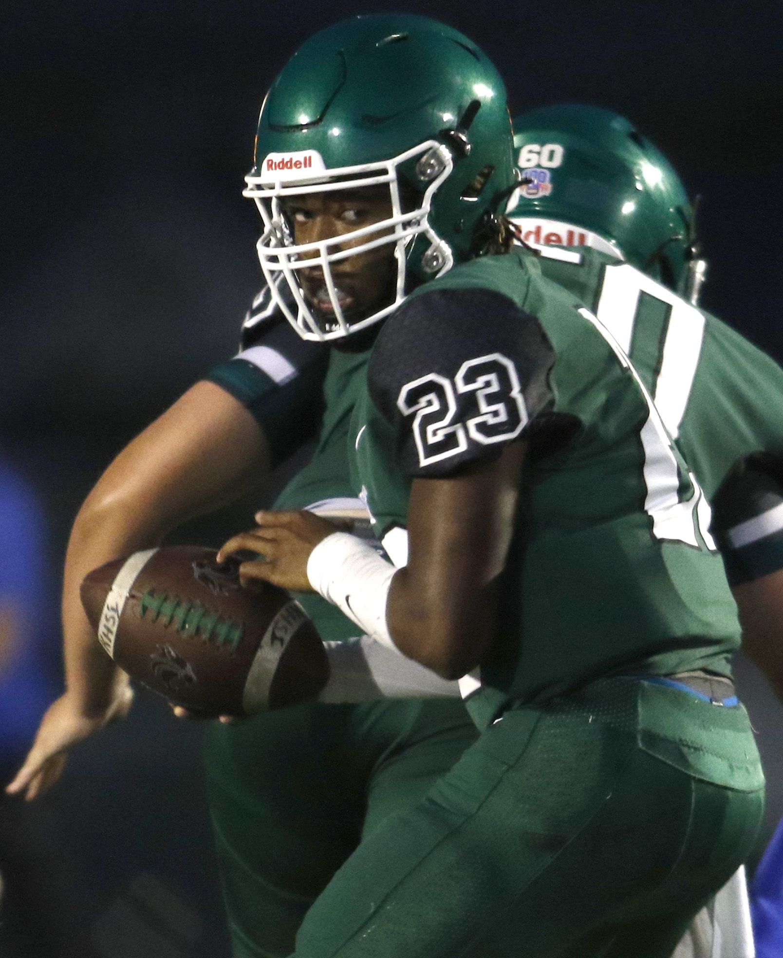 Kennedale quarterback Jeremiah Myers (23) spins to handoff to his running back during first...