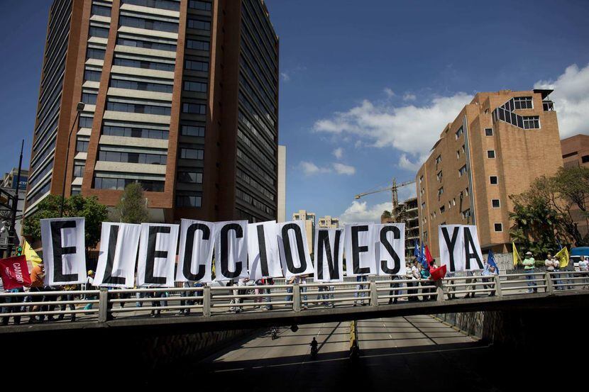Unos cartelones dicen “elecciones ya” durnate una manifestación en Caracas, el lunes 23 de...