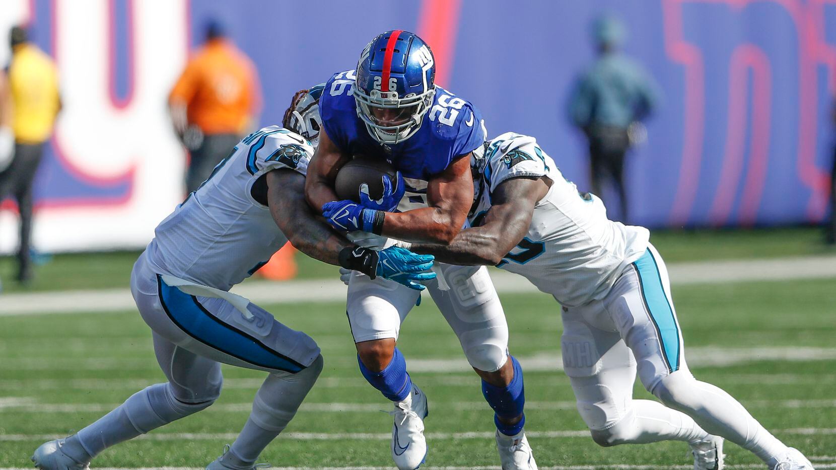 Carolina Panthers defenders try to tackle New York Giants' Saquon Barkley, center, during...
