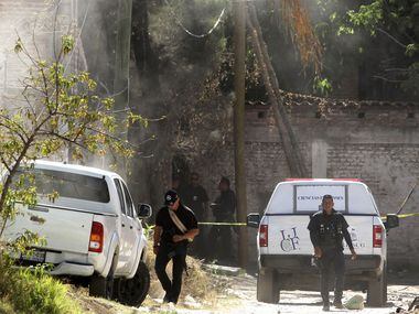 Forensic personnel and police officers are seen outside a criminal hideout where eight...