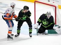 New York Islanders' Kyle Palmieri (21) and Dallas Stars' Nils Lundkvist, center, look on as...