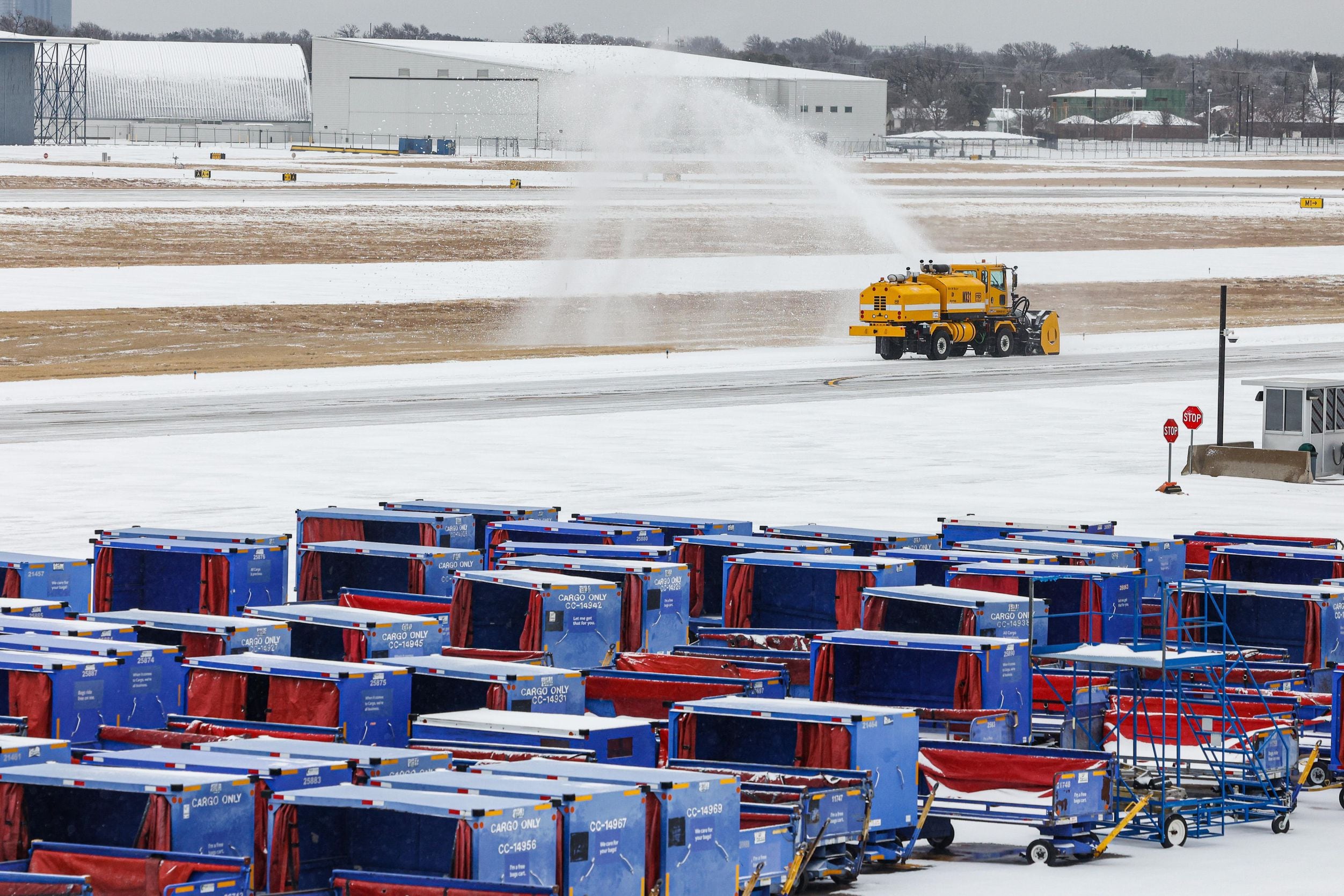 A truck removes snow over Dallas Love Field runway in Dallas on Thursday, February 3, 2022....