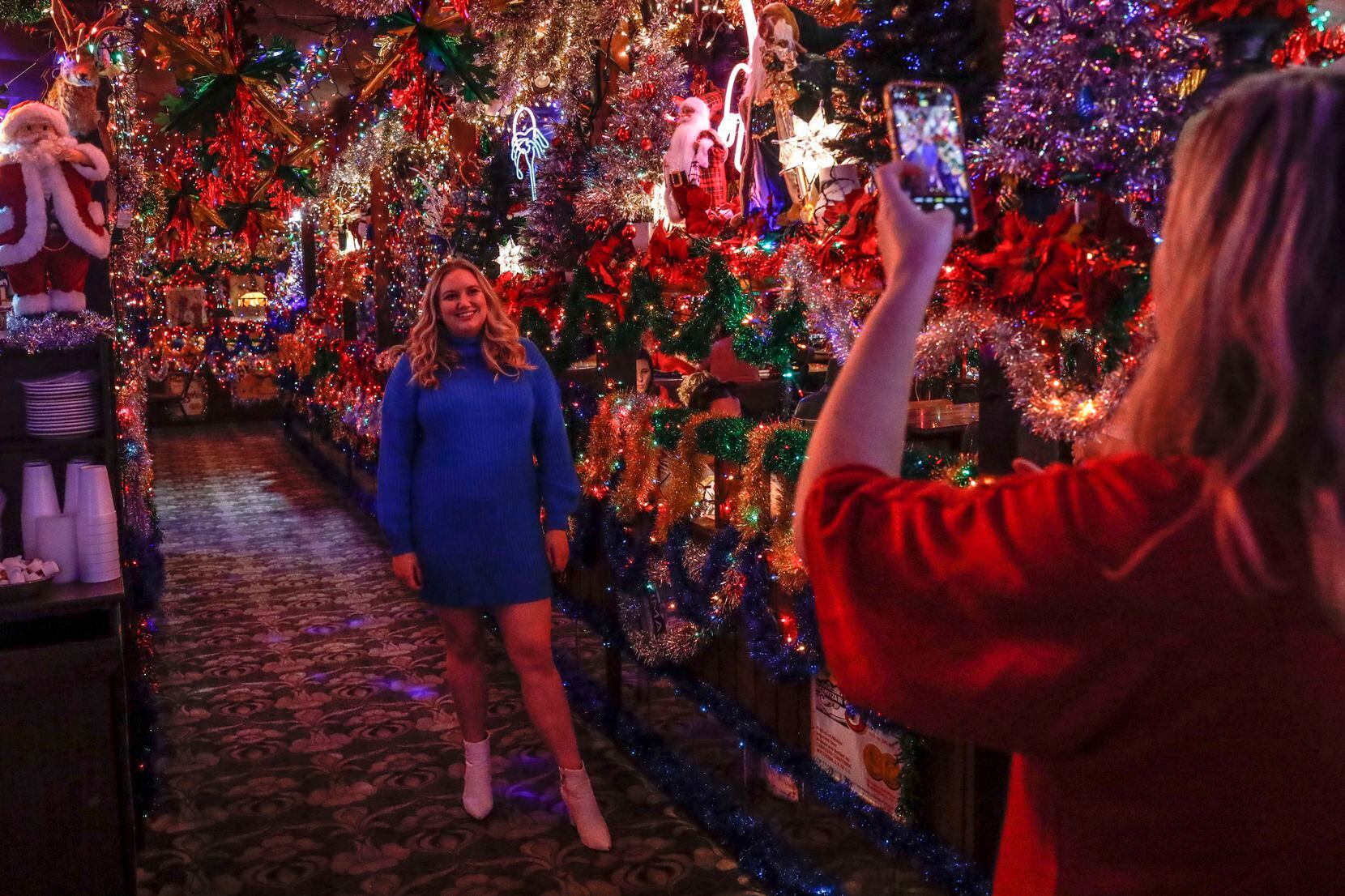 Elizabeth Brown gets her photo taken by her sister, Nicole Brown, among the Christmas...