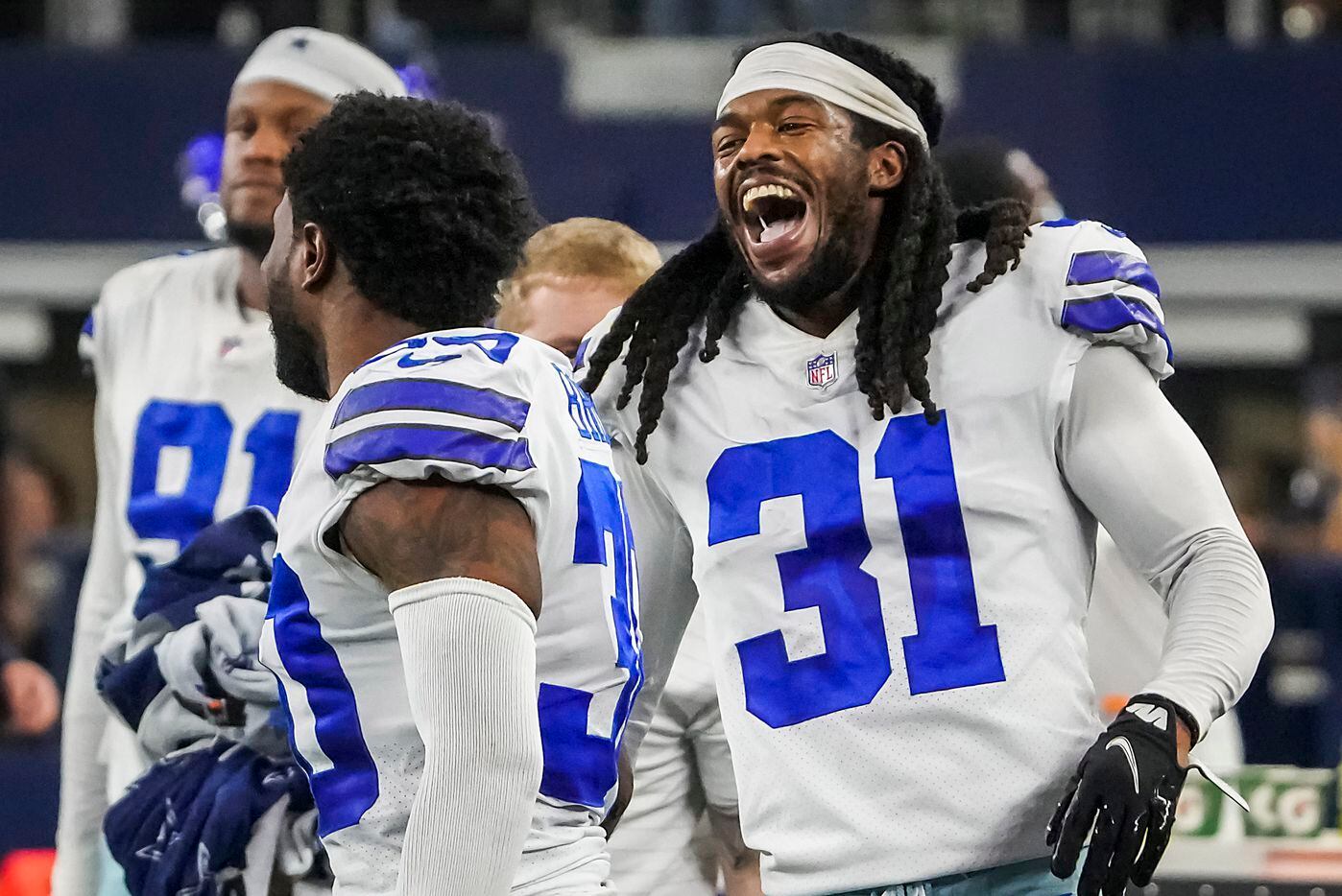 Dallas Cowboys cornerback Maurice Canady (31) laughs on the bench with cornerback Anthony Brown (30) during the second half of an NFL football game against the Washington Football Team at AT&T Stadium on Sunday, Dec. 26, 2021, in Arlington. The Cowboys won the game 56-14.