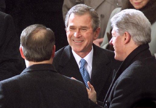 After taking the oath of office, President George W. Bush shook hands with Bill Clinton and...
