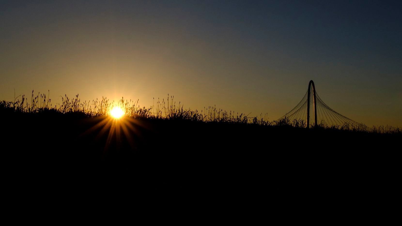 The sun setting behind the Margaret Hunt Hill Bridge on Wednesday, May 15, 2019, in Dallas. 