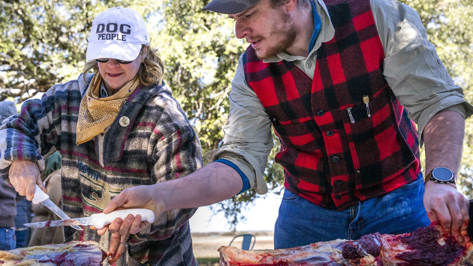 Jacob Arthur (right) from Austin, Texas, gives advice to Cindee Klement as they debone a cut of bison during a daylong bison field harvest event at Roam Ranch in Fredericksburg, Texas, on Sunday, Jan. 19, 2020.