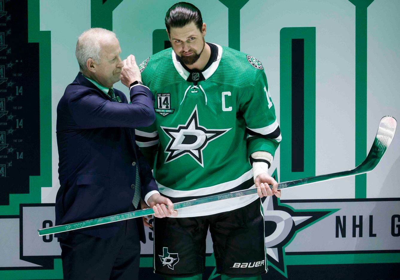 Dallas Stars general manger Jim Nill (left) presents left wing Jamie Benn (14) with a silver...