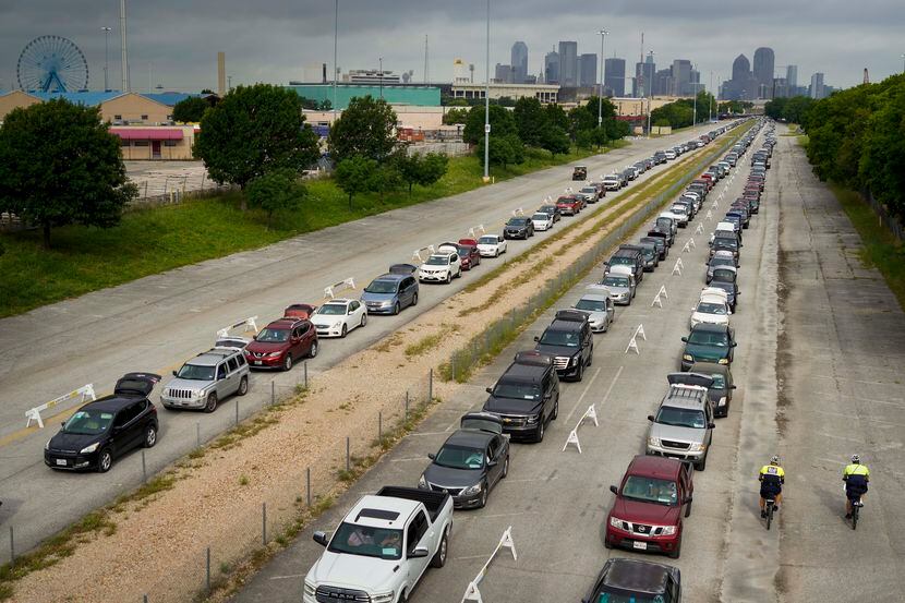 Cars lined up for distributions from the North Texas Food Bank at Fair Park on May 14. About...