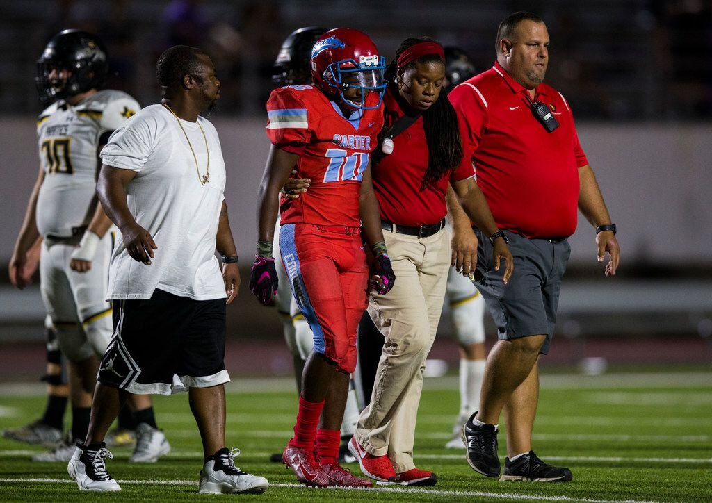 Carter wide receiver Montray Borner (10) is escorted off the field with an injury during the...