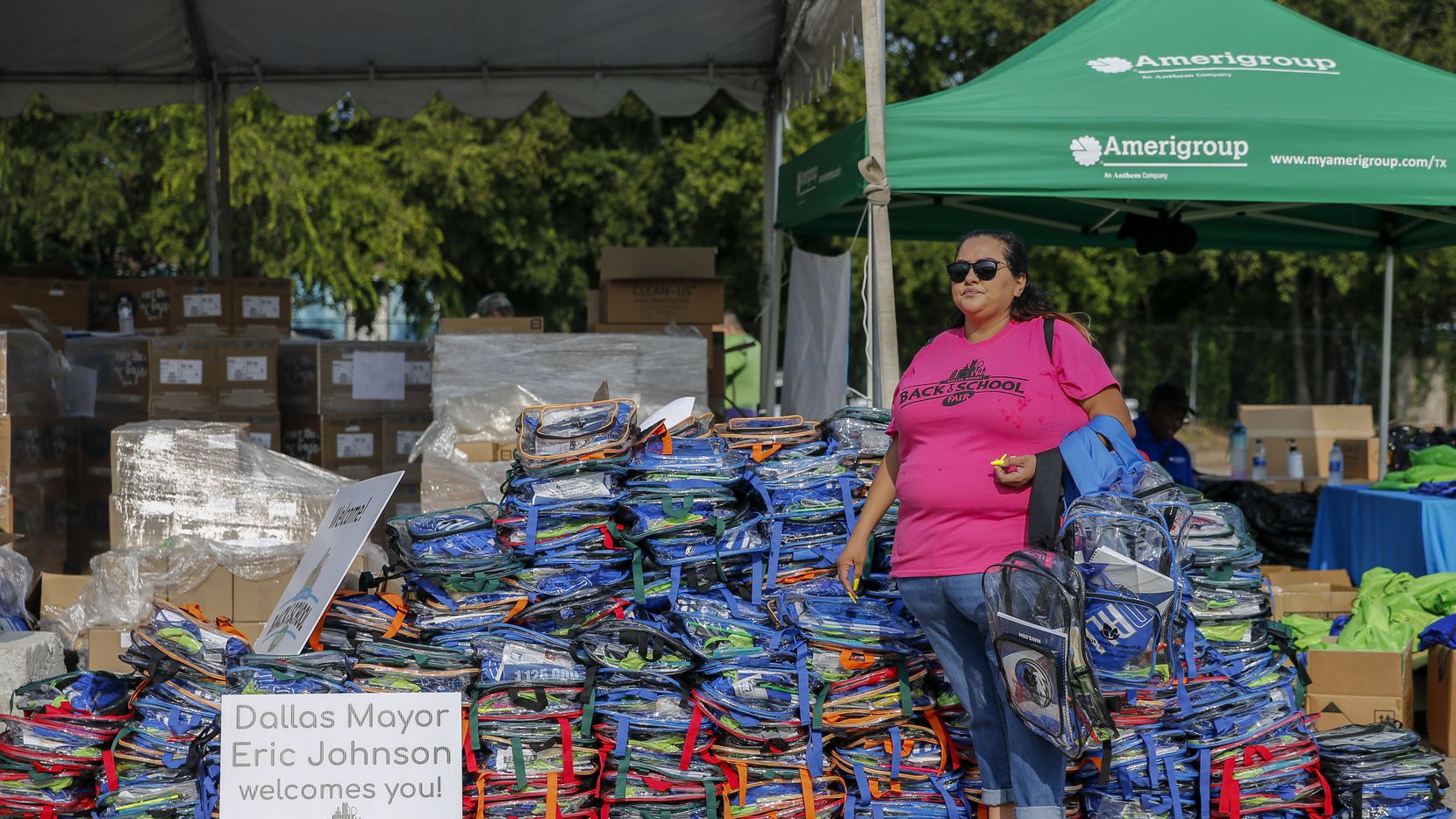 Volunteer Alex Tadeo waits to load backpacks into cars during the mayor’s back to school...