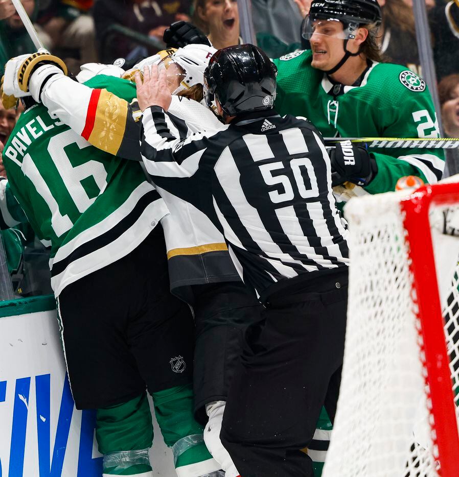 A referee attempts to pull players off during a fight in the third period of a game, on...